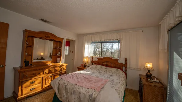 a bed room with two bed and a mirror