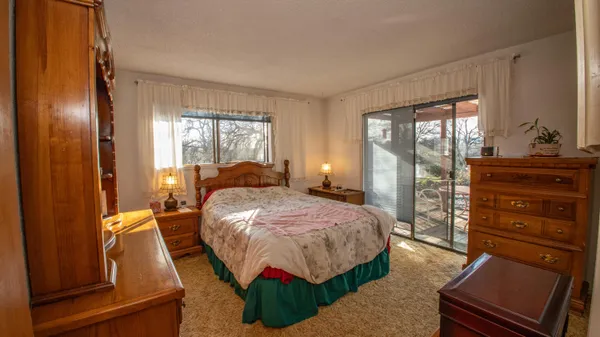 a bedroom with a bed and large windows