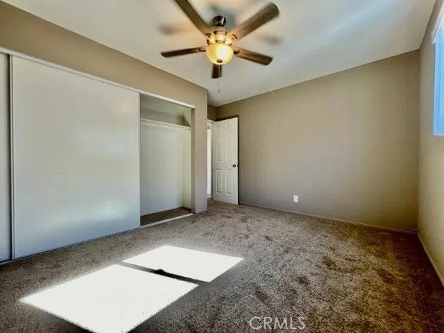 an empty room with a window and a ceiling fan