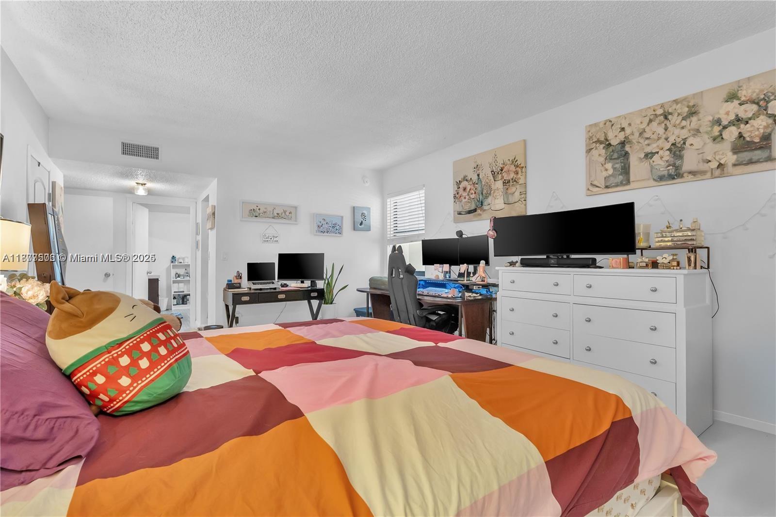 491 Ives Dairy Road, Unit 2025 Miami, FL 33179 - Photo 12 of 20 a bedroom with a bed and flat screen tv