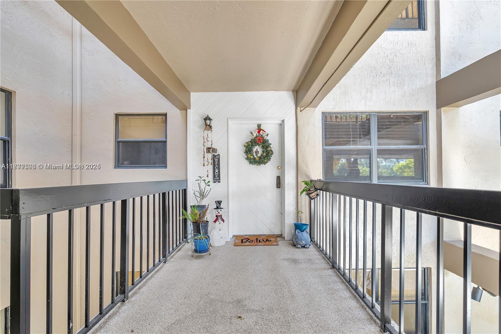 491 Ives Dairy Road, Unit 2025 Miami, FL 33179 - Photo 19 of 20 a view of a hallway with wooden floor and windows