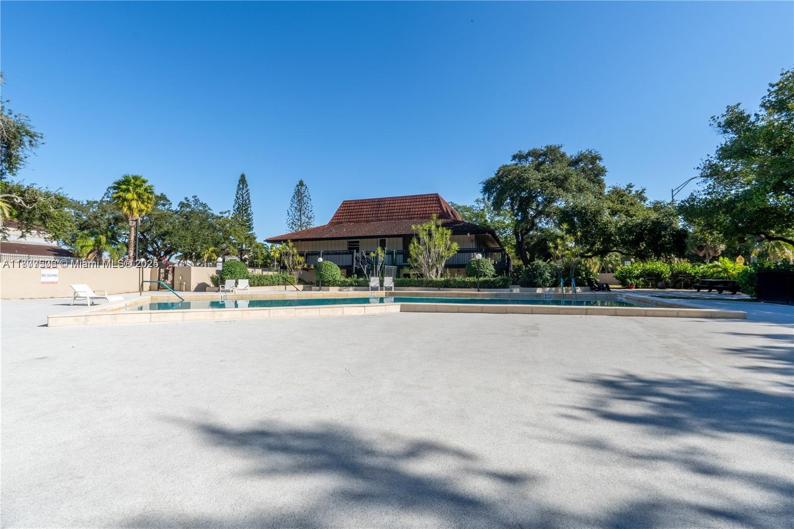 491 Ives Dairy Road, Unit 2025 Miami, FL 33179 - Photo 2 of 20 a view of swimming pool with outdoor seating and trees in the background