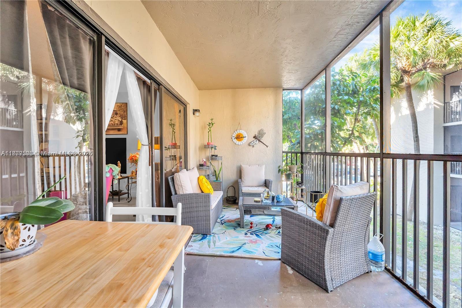 491 Ives Dairy Road, Unit 2025 Miami, FL 33179 - Photo 4 of 20 a outdoor space with the couches and dining table with the garden view