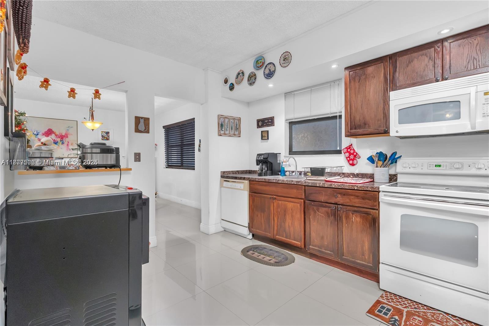 491 Ives Dairy Road, Unit 2025 Miami, FL 33179 - Photo 5 of 20 a kitchen with a sink stove and cabinets