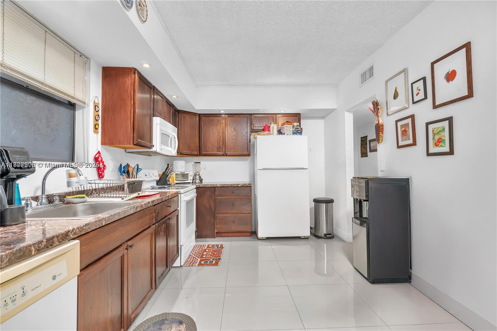 491 Ives Dairy Road, Unit 2025 Miami, FL 33179 - Photo 6 of 20 a kitchen with a refrigerator and a sink
