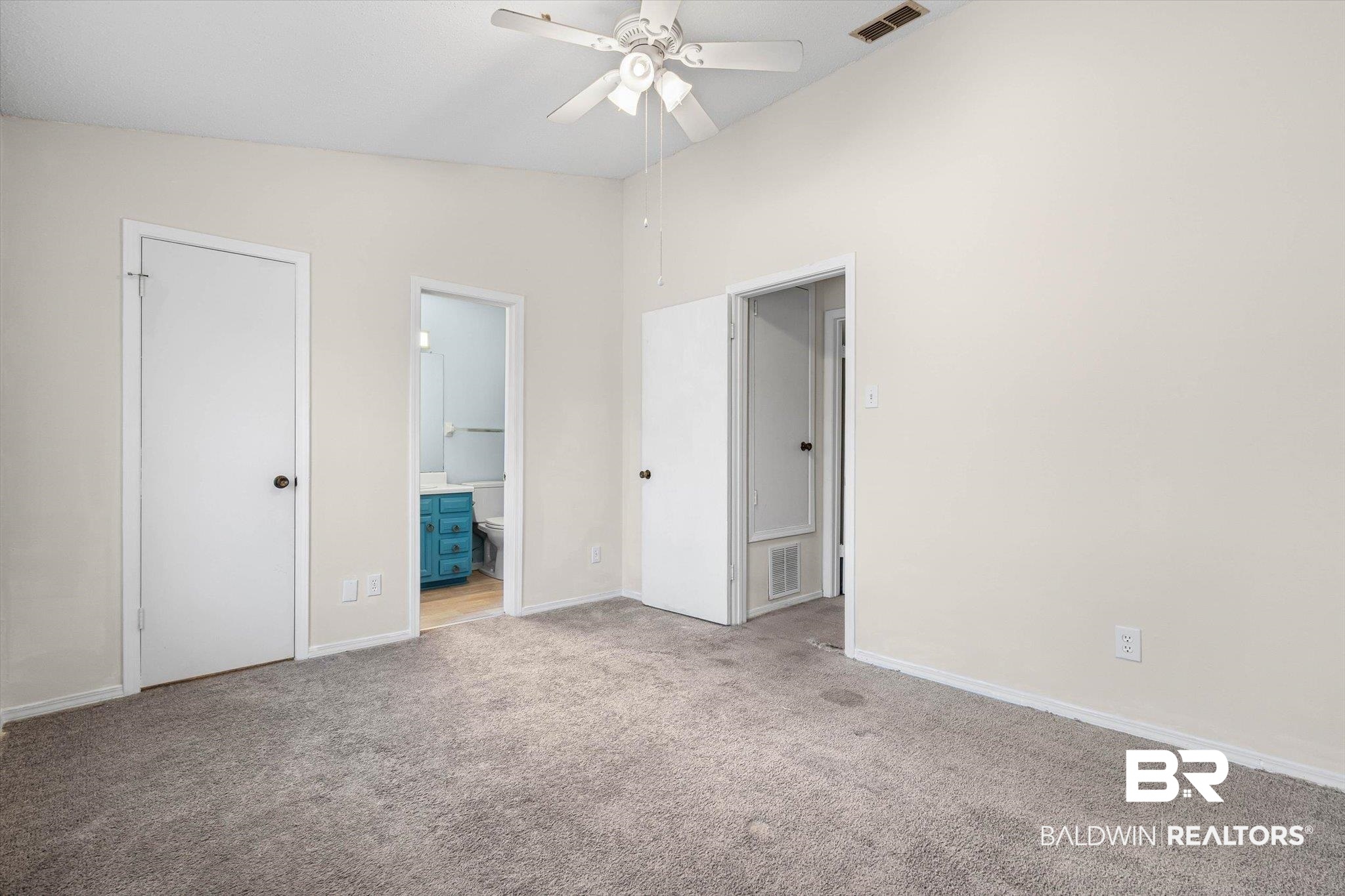 5900 Grelot Road, Unit 504 Mobile, AL 36609 - Photo 15 of 24 Unfurnished bedroom featuring light carpet, connected bathroom, lofted ceiling, and a ceiling fan