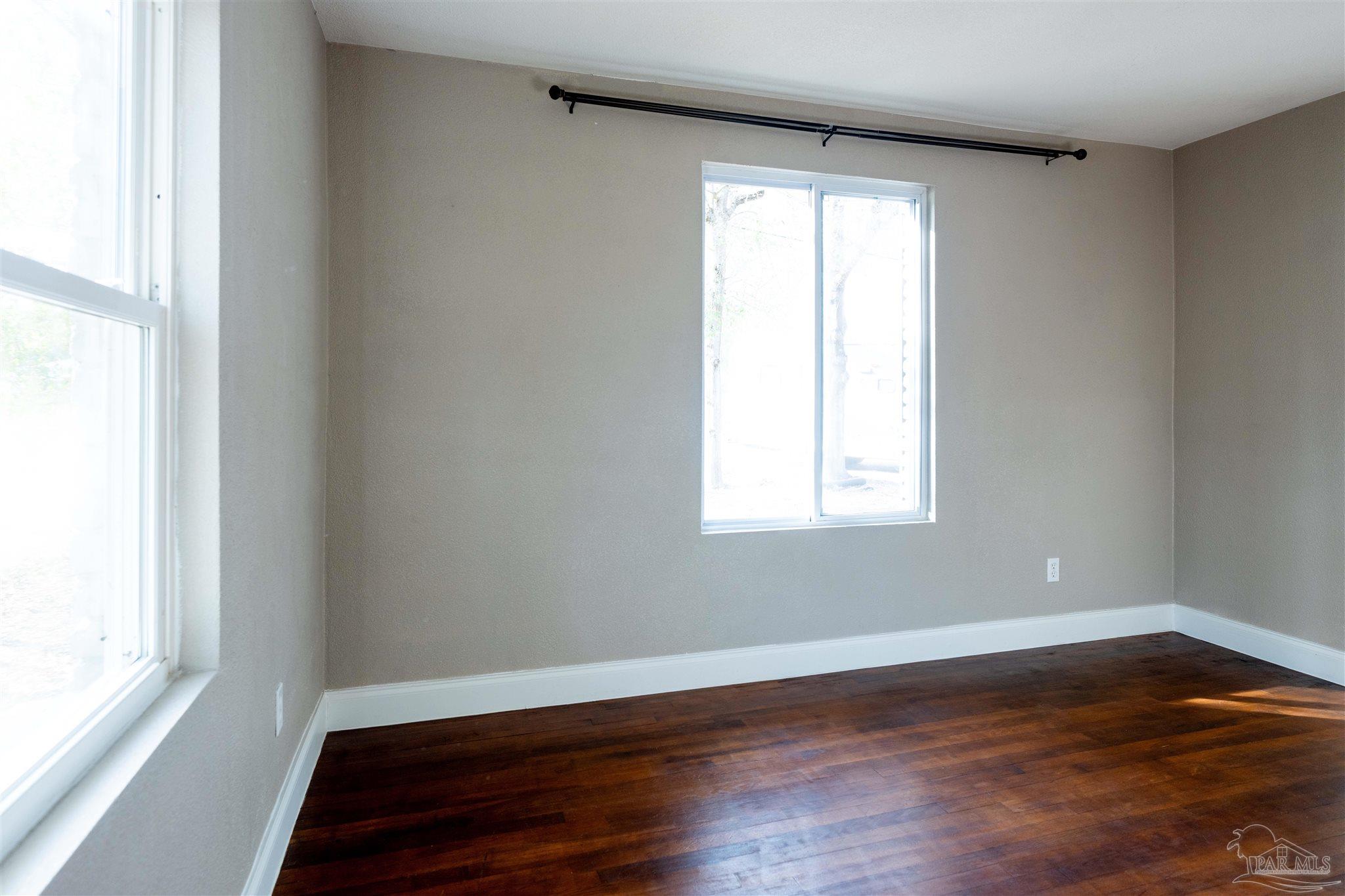 409 Frisco Road Pensacola, FL 32507 - Photo 13 of 27 a view of an empty room with wooden floor and a window