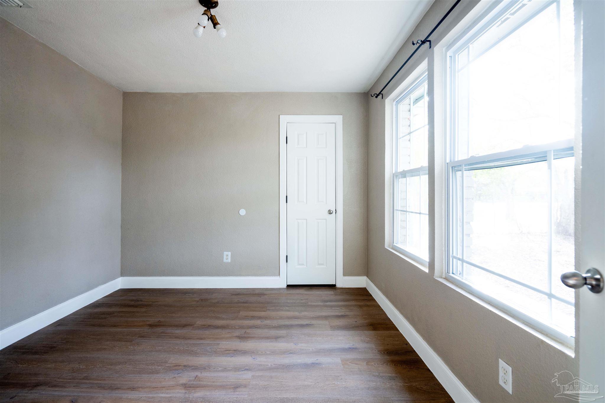 409 Frisco Road Pensacola, FL 32507 - Photo 15 of 27 a view of an empty room with wooden floor and a window
