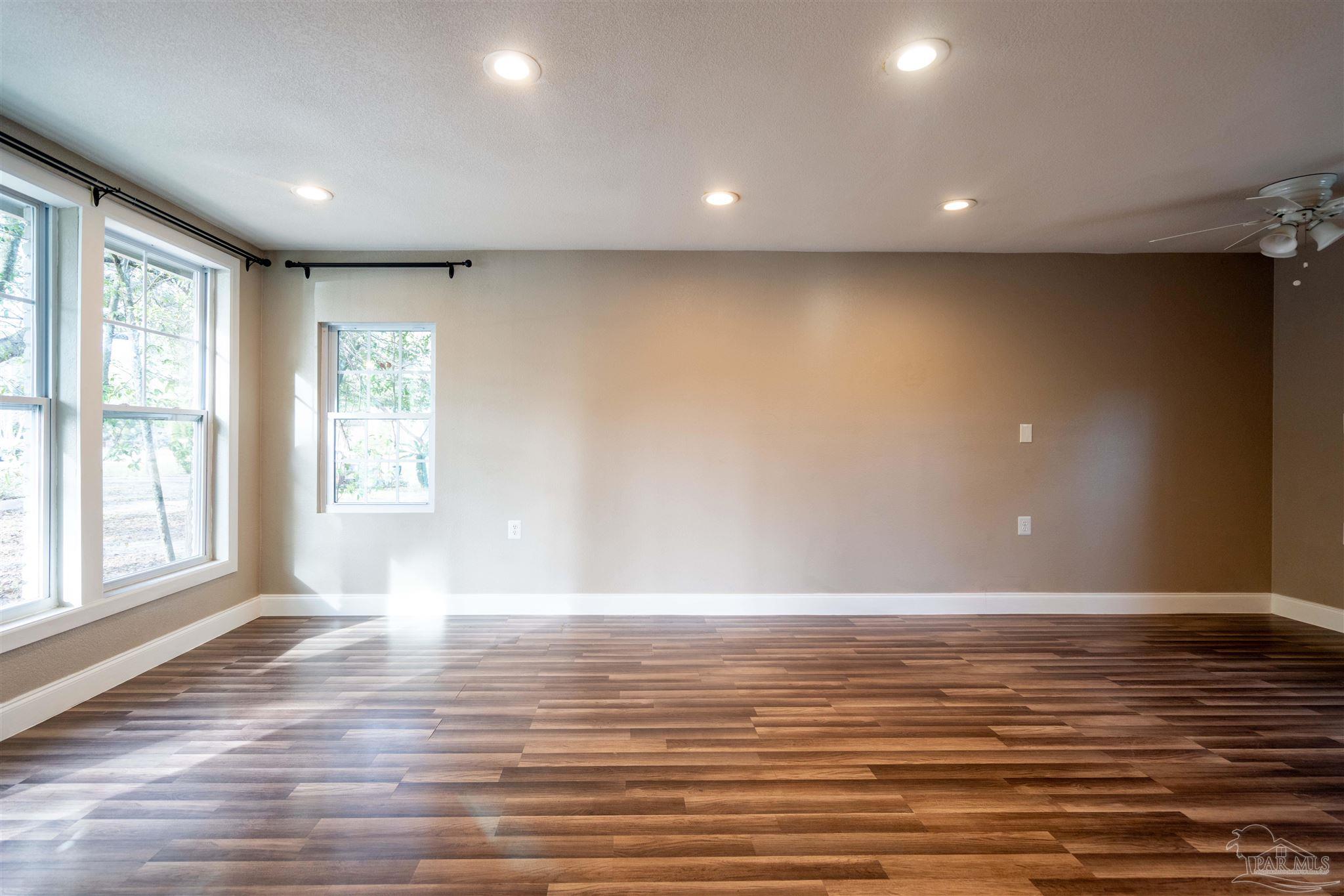 409 Frisco Road Pensacola, FL 32507 - Photo 16 of 27 a view of an empty room with wooden floor and a window