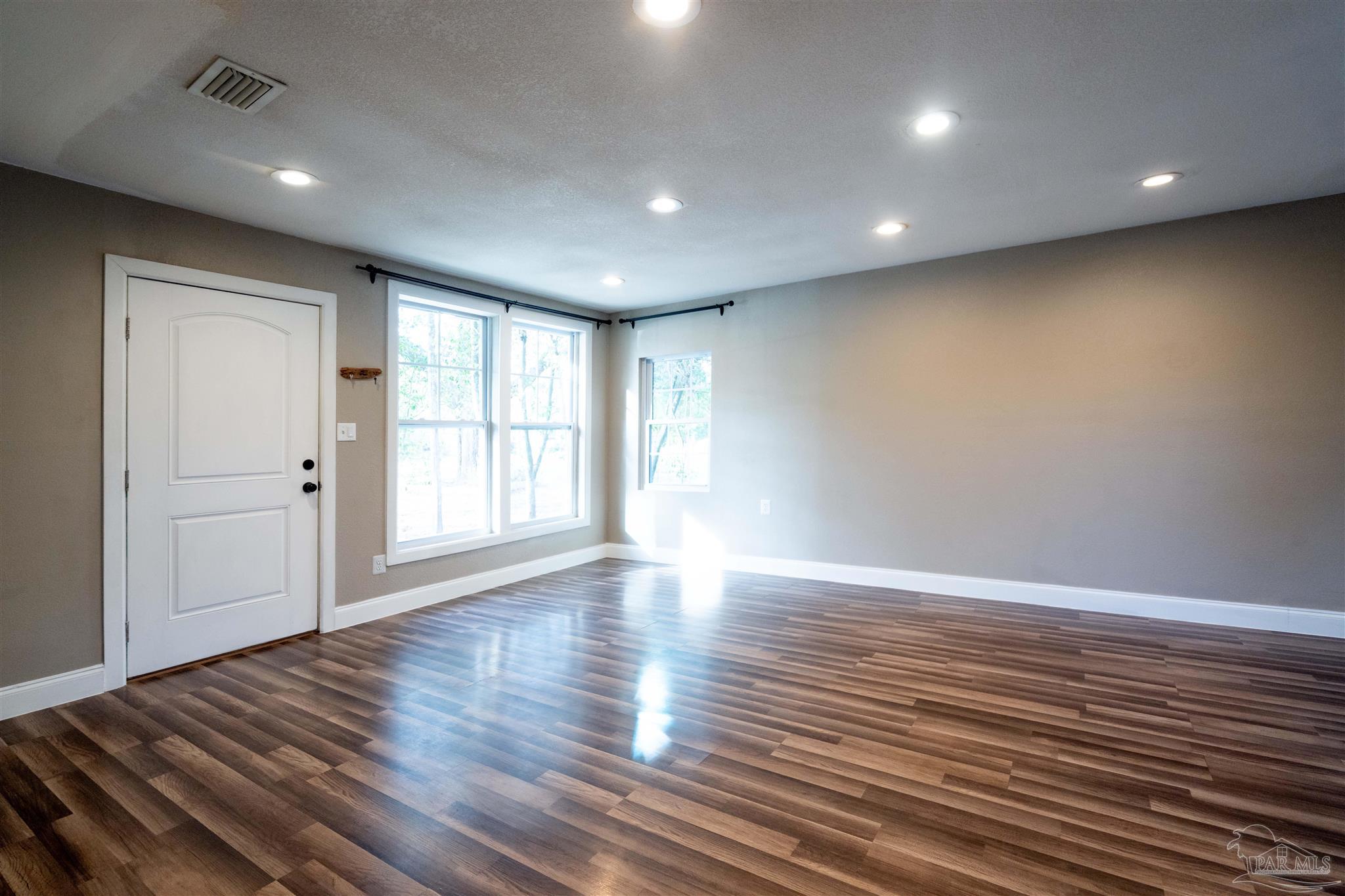 409 Frisco Road Pensacola, FL 32507 - Photo 17 of 27 a view of an empty room with wooden floor and a window