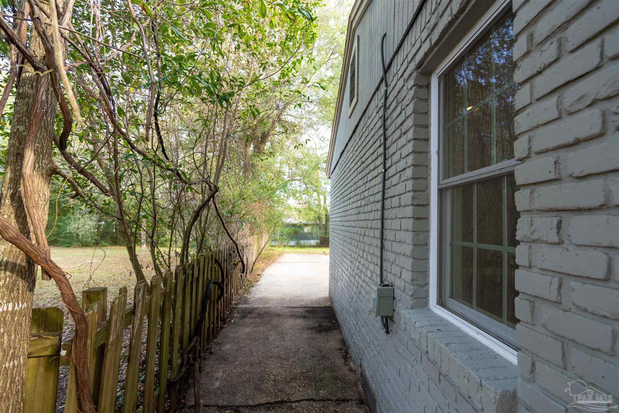 409 Frisco Road Pensacola, FL 32507 - Photo 18 of 27 a view of a pathway of a house with backyard of the house
