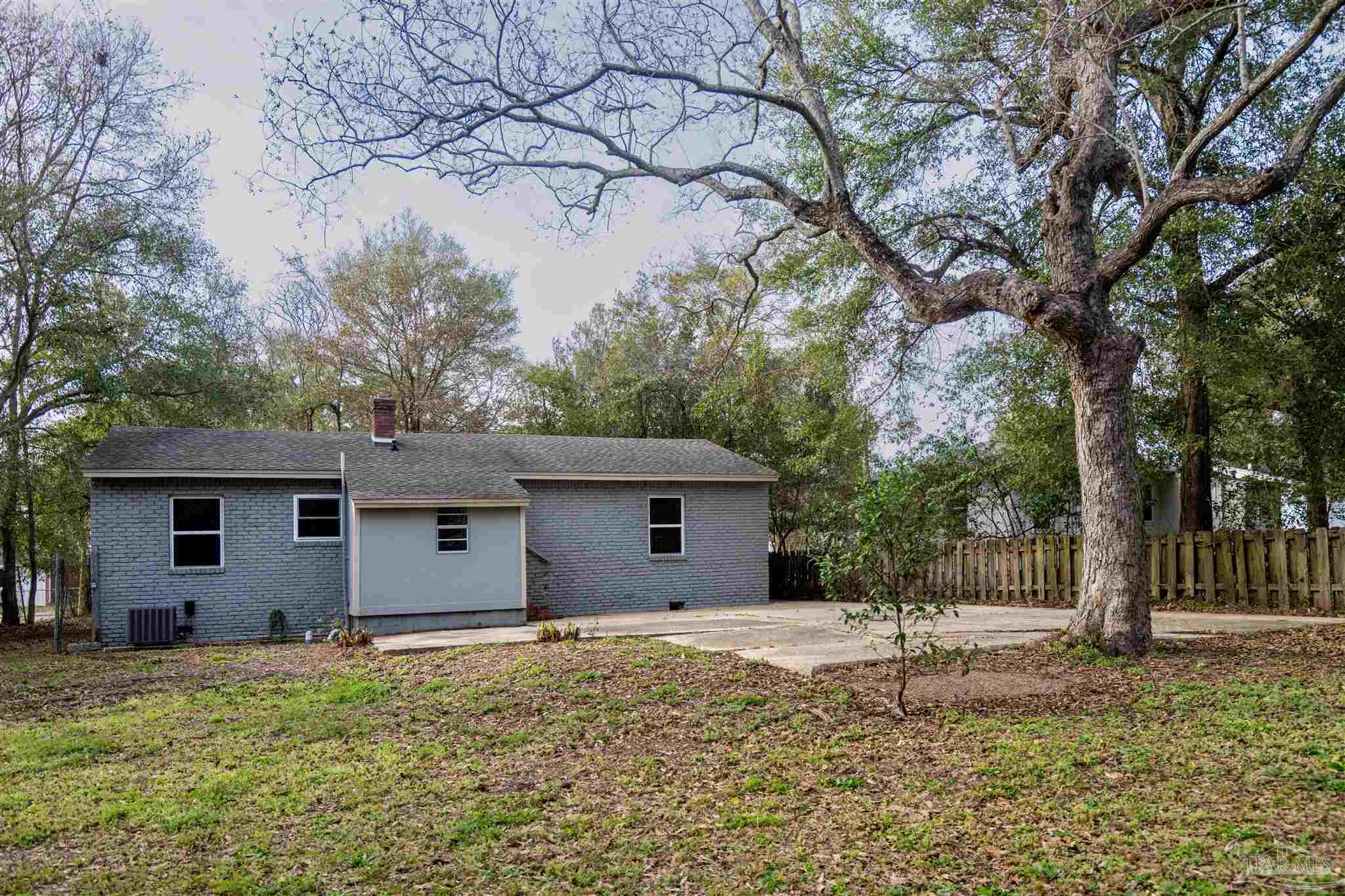 409 Frisco Road Pensacola, FL 32507 - Photo 23 of 27 a backyard of house with a barbeque oven and large tree