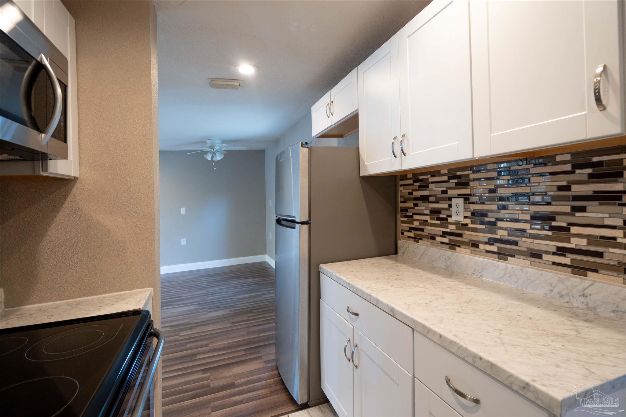 409 Frisco Road Pensacola, FL 32507 - Photo 6 of 27 a kitchen with a sink and a stove top oven