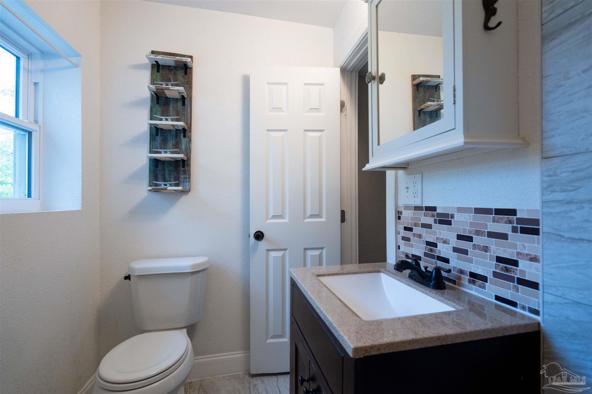 409 Frisco Road Pensacola, FL 32507 - Photo 8 of 27 a bathroom with a sink toilet and mirror