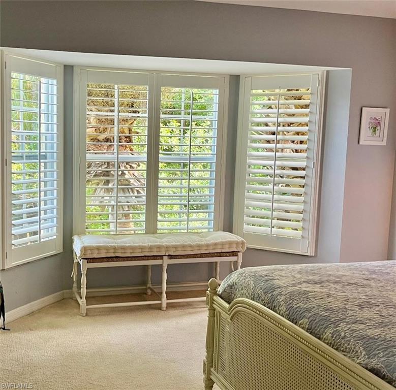 8380 Mystic Greens Way, Unit 1303 Naples, FL 34113 - Photo 13 of 25 a bed sitting in a room next to a window