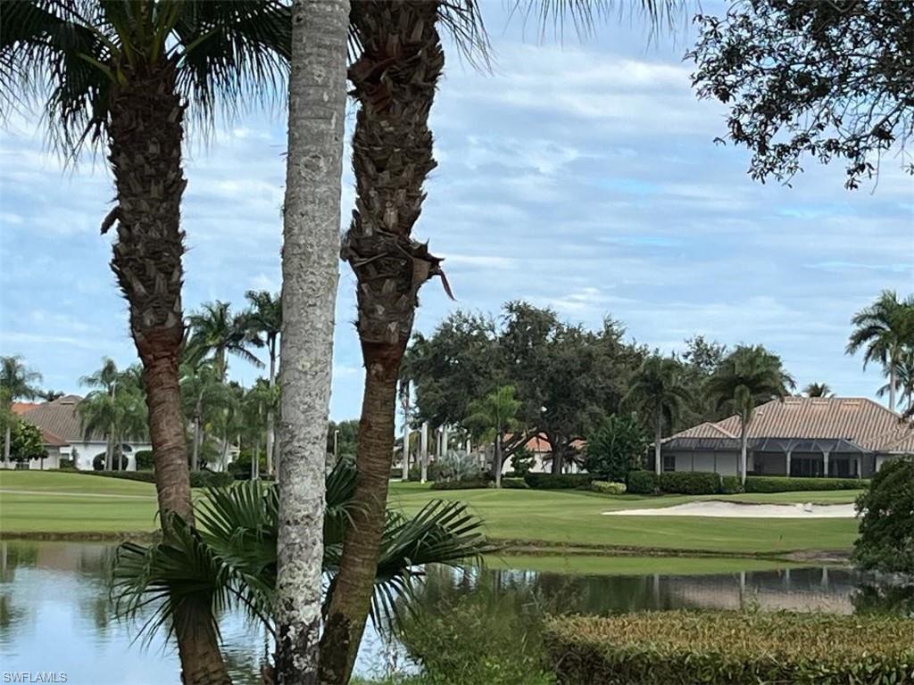 8380 Mystic Greens Way, Unit 1303 Naples, FL 34113 - Photo 6 of 25 a front view of a house with a yard and trees