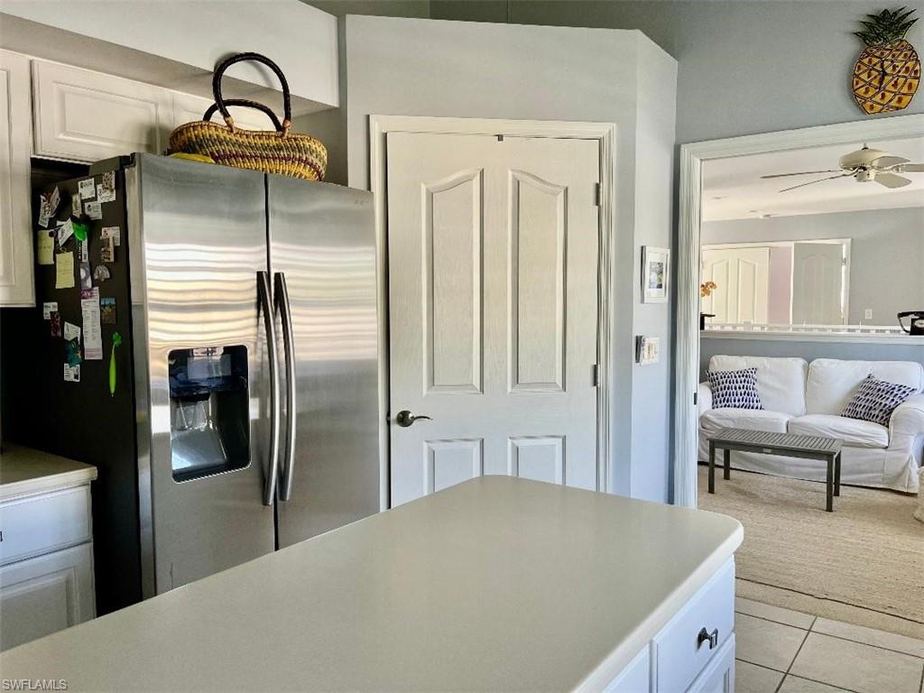 8380 Mystic Greens Way, Unit 1303 Naples, FL 34113 - Photo 7 of 25 a kitchen with a refrigerator and table chair
