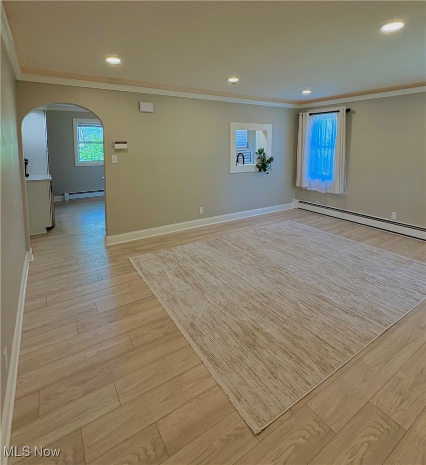 24836 Kennedy Ridge Road North Olmsted, OH 44070 - Photo 5 of 29 Unfurnished room with baseboards, ornamental molding, light wood finished floors, and arched walkways