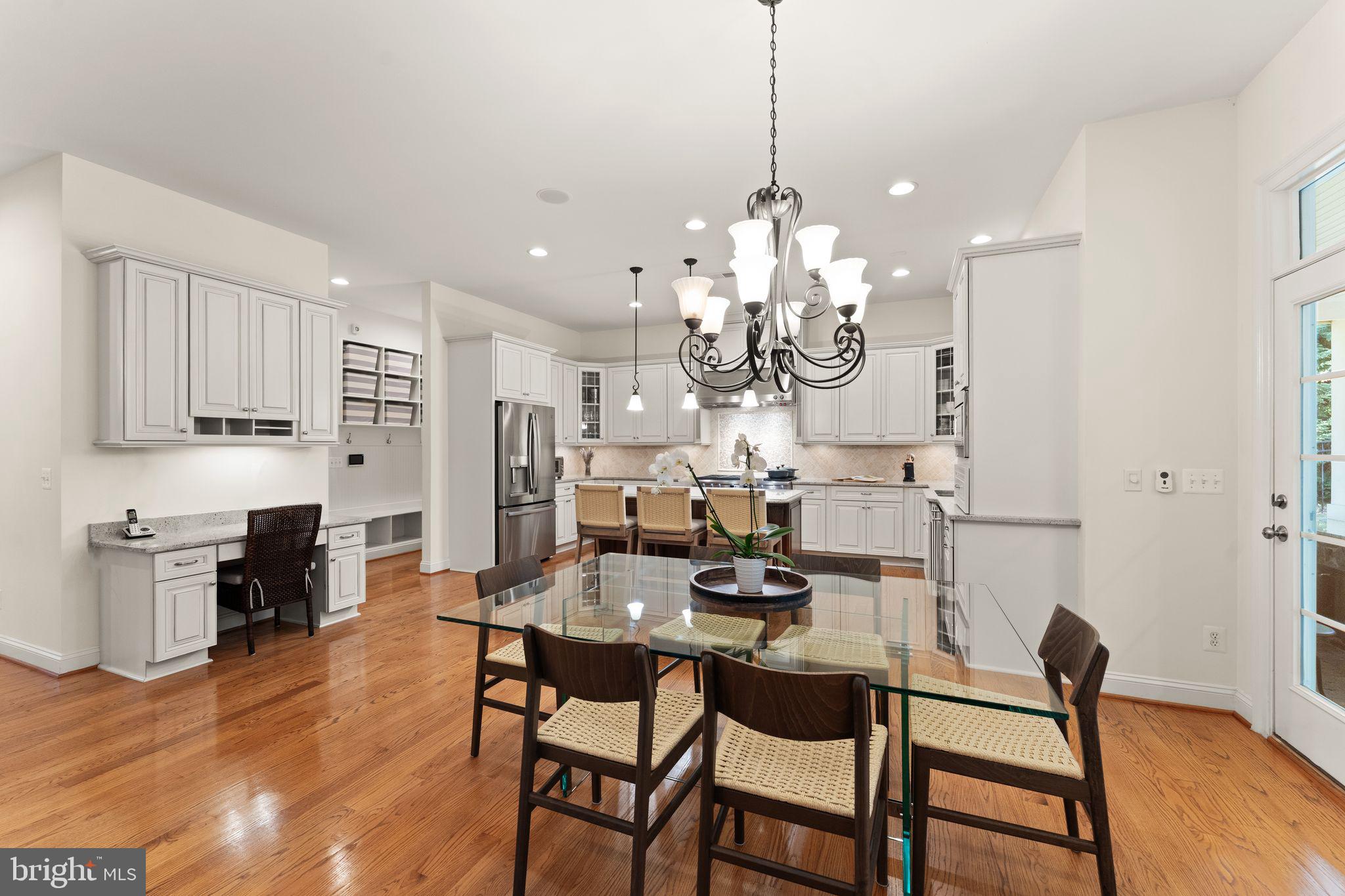 9603 Thistle Ridge Lane Vienna, VA 22182 - Photo 20 of 73 a kitchen with stainless steel appliances kitchen island granite countertop a dining table chairs and white cabinets