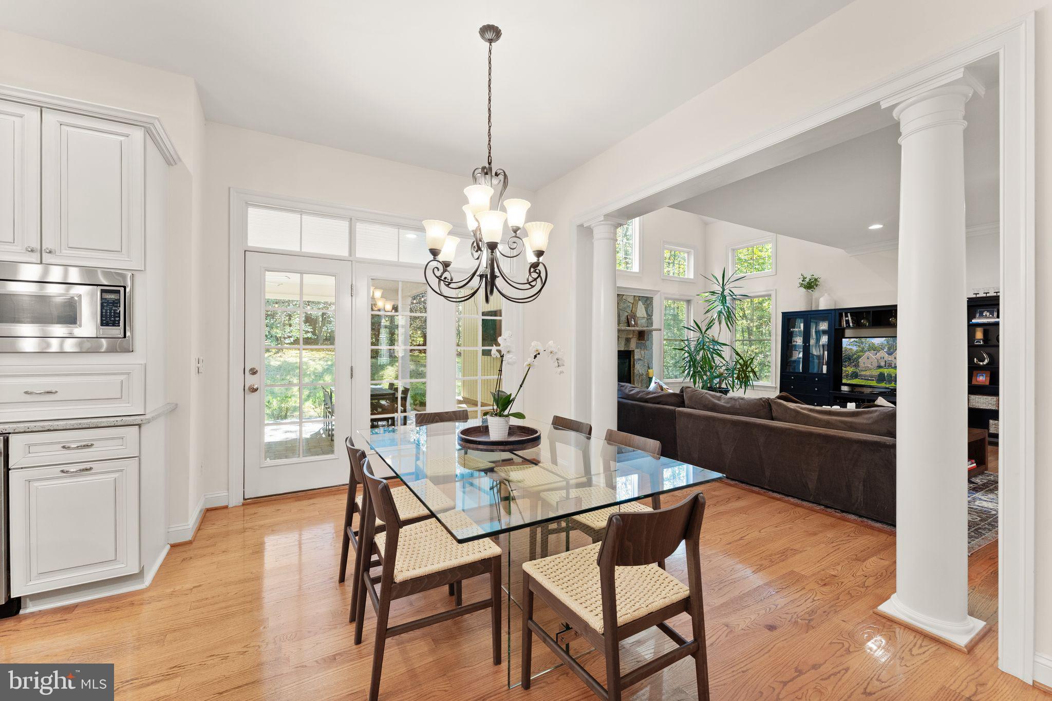 9603 Thistle Ridge Lane Vienna, VA 22182 - Photo 21 of 73 a dining room with wooden floor a chandelier a wooden table and chairs