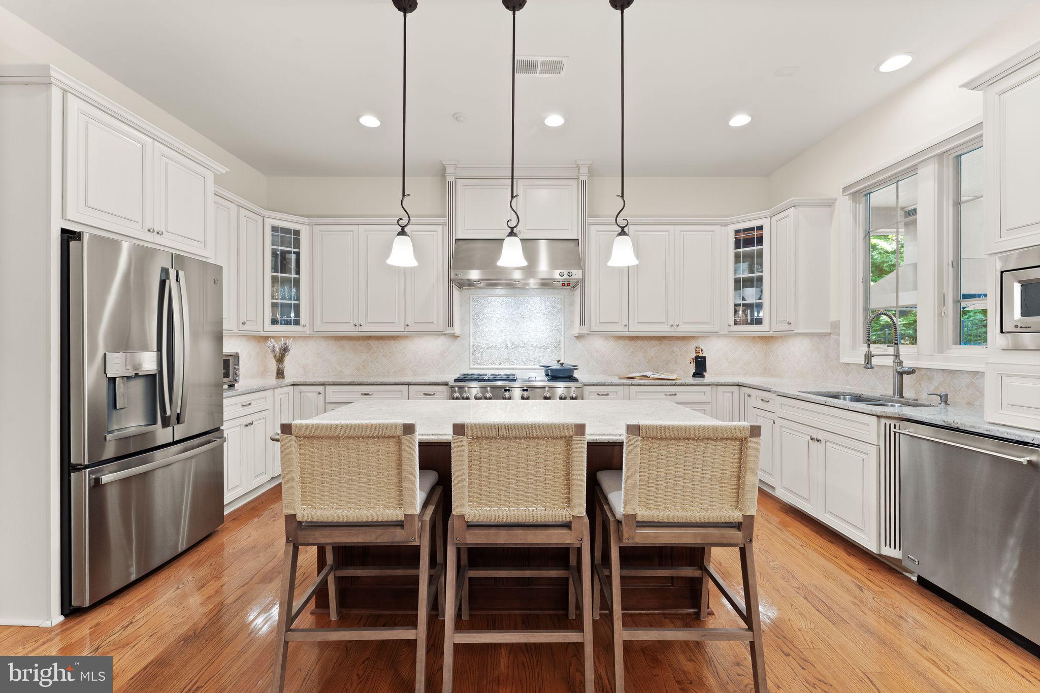 9603 Thistle Ridge Lane Vienna, VA 22182 - Photo 22 of 73 a kitchen with stainless steel appliances granite countertop a dining table chairs stove refrigerator and microwave