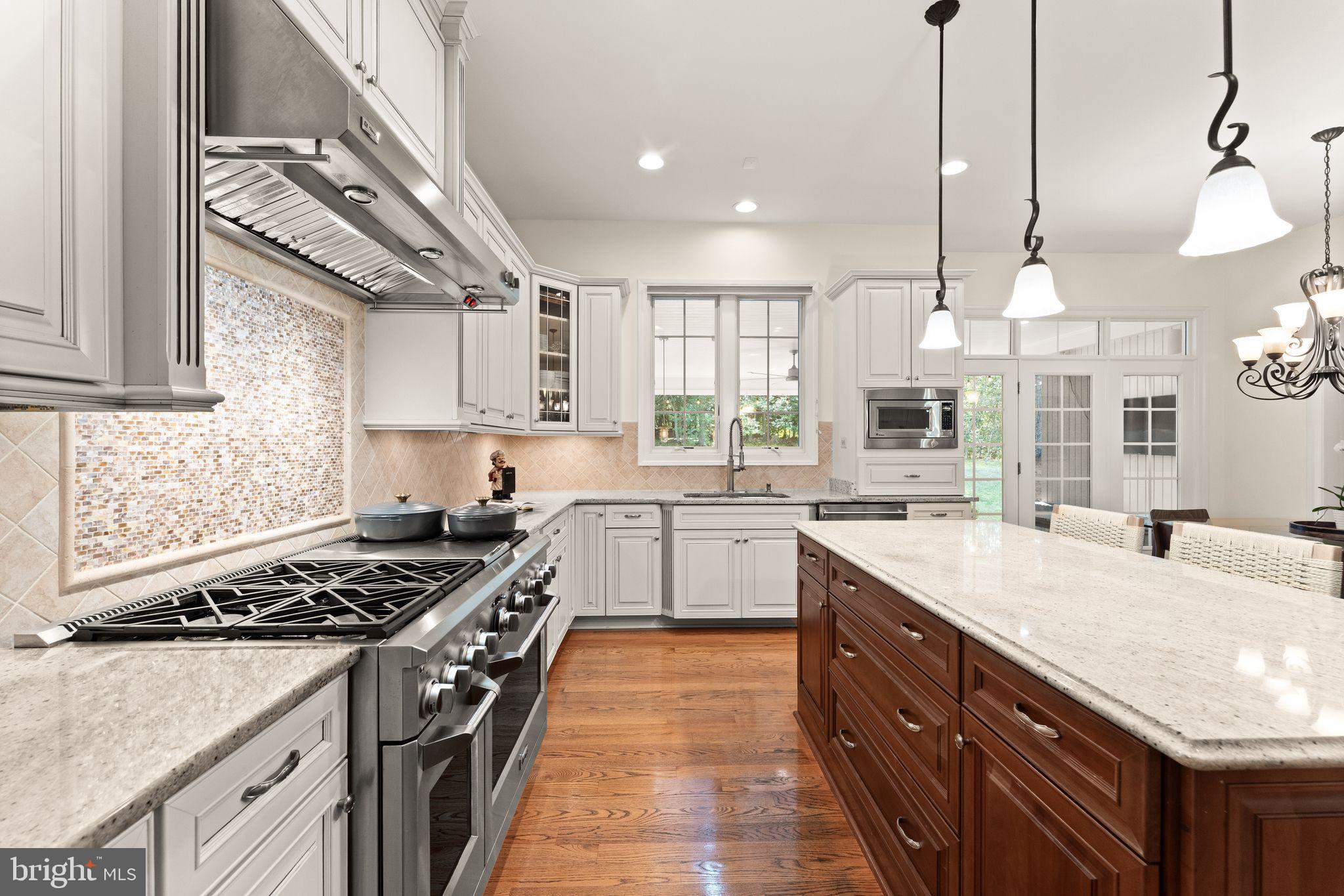 9603 Thistle Ridge Lane Vienna, VA 22182 - Photo 24 of 73 a kitchen with stainless steel appliances granite countertop a sink a stove and a wooden floors