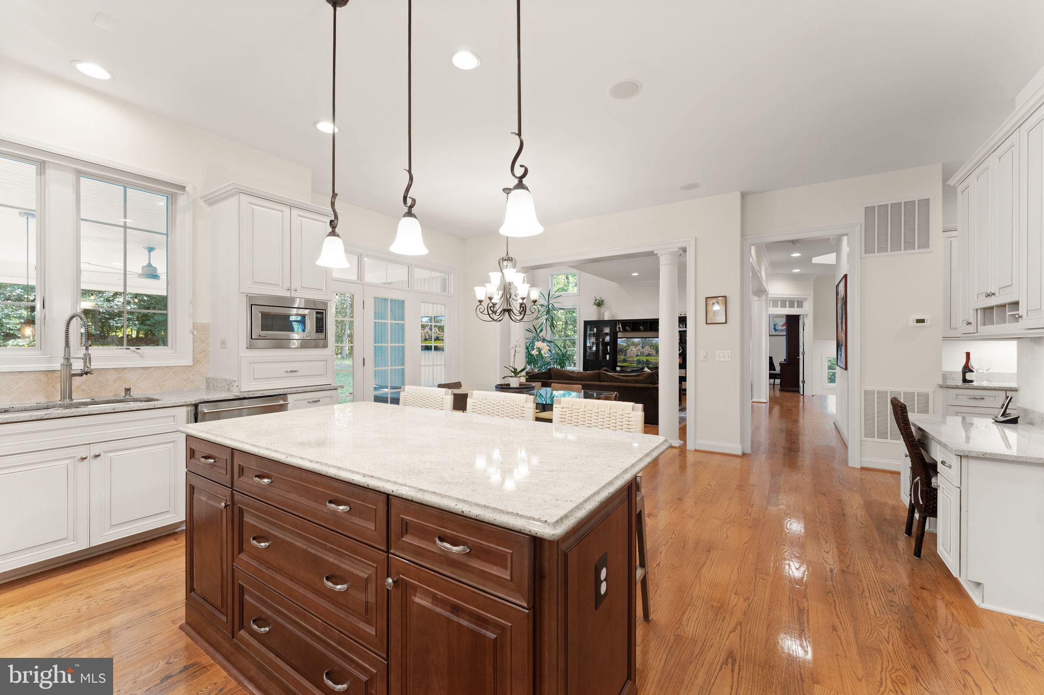 9603 Thistle Ridge Lane Vienna, VA 22182 - Photo 25 of 73 a large kitchen with kitchen island a stove a sink a center island and cabinets