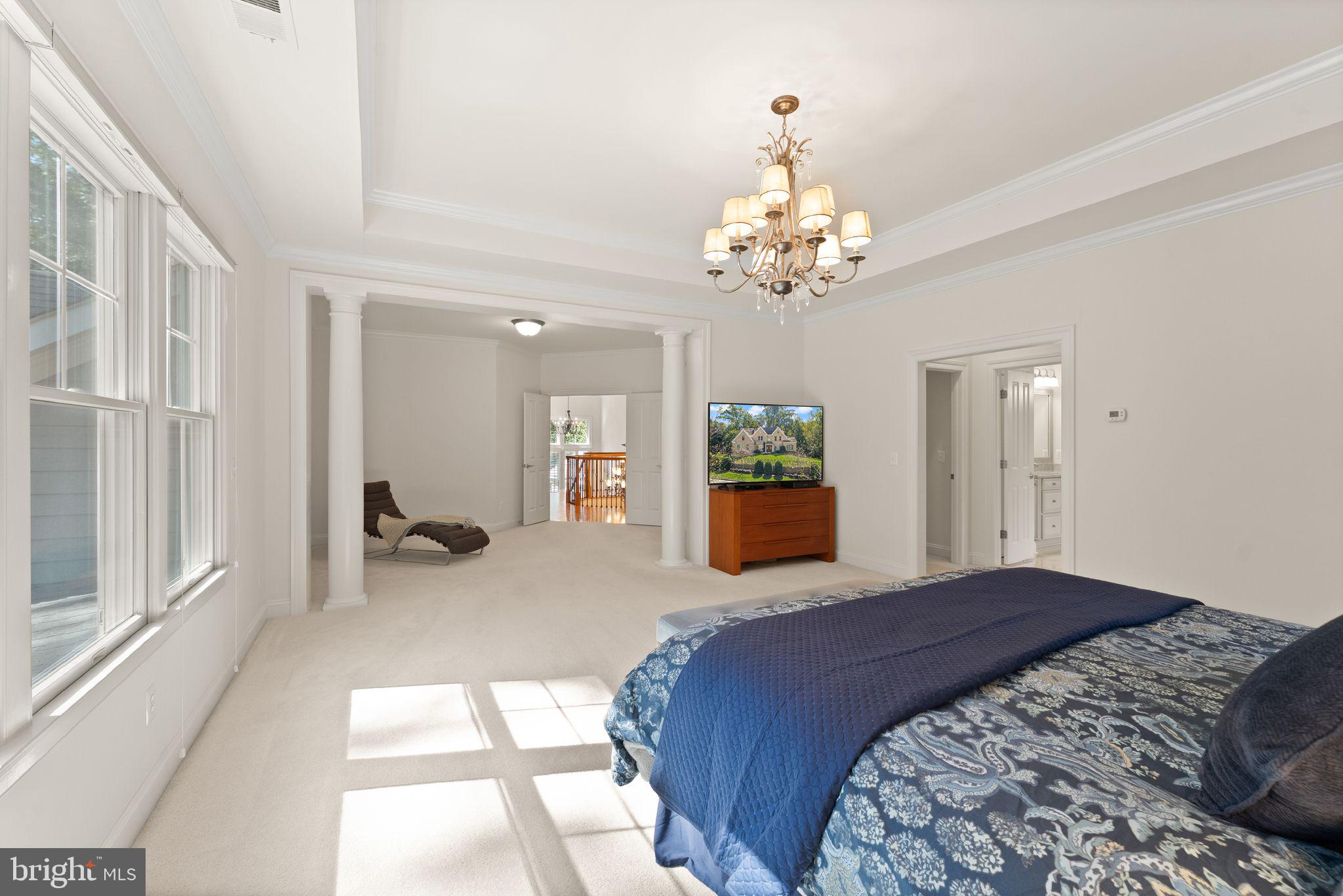 9603 Thistle Ridge Lane Vienna, VA 22182 - Photo 33 of 73 a spacious bedroom with a large bed and chandelier