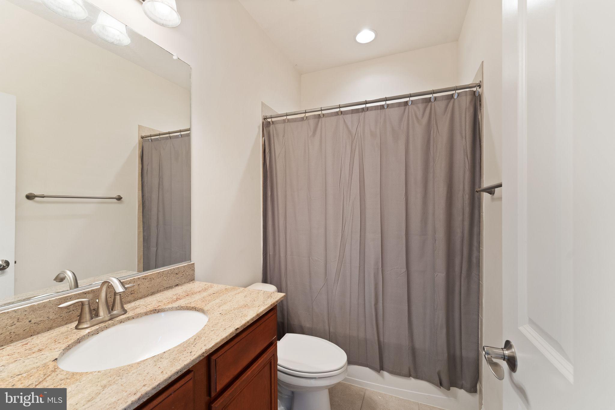 9603 Thistle Ridge Lane Vienna, VA 22182 - Photo 42 of 73 a bathroom with a granite countertop sink toilet and a mirror