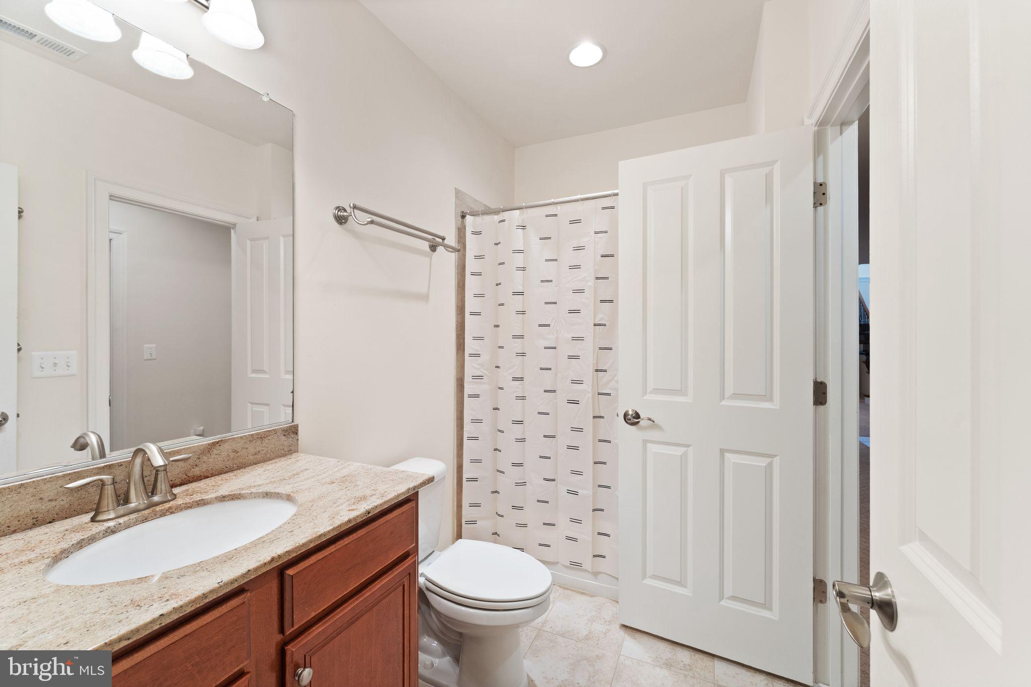 9603 Thistle Ridge Lane Vienna, VA 22182 - Photo 60 of 73 a bathroom with a granite countertop sink toilet and shower