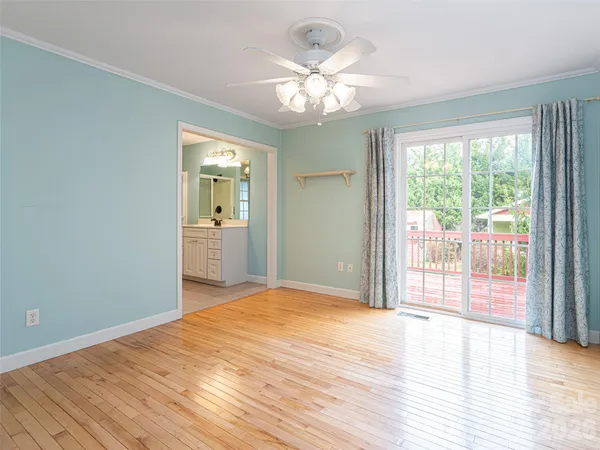 a view of a big room with wooden floor and windows
