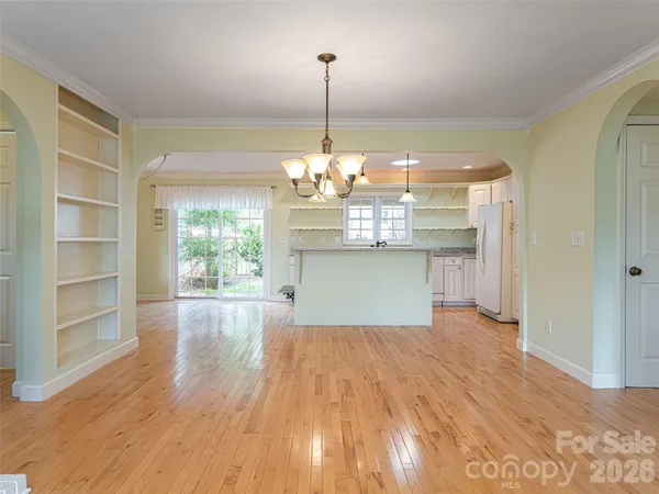 a view of a room with a chandelier and wooden floor