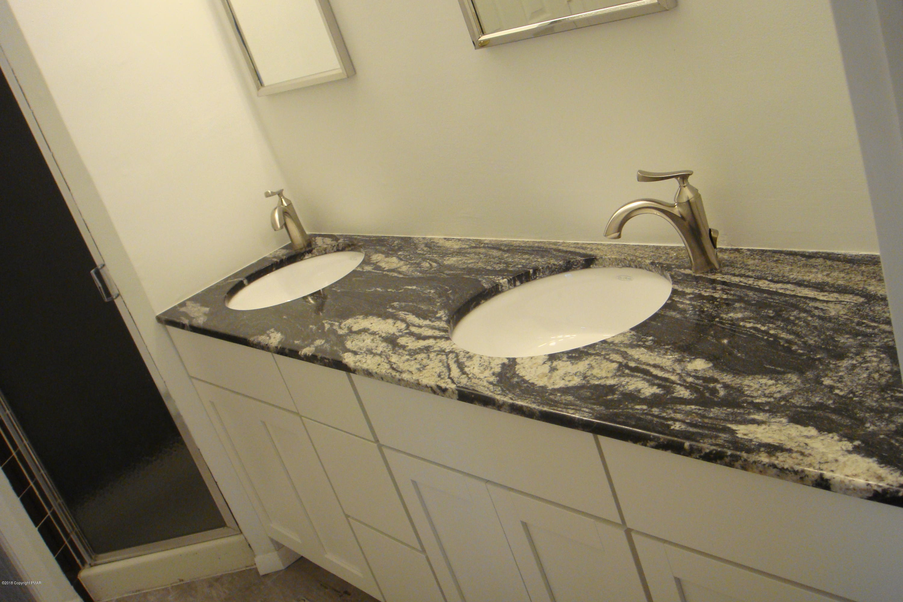 6375 Decker Road Bushkill, PA 18324 - Photo 36 of 60 a bathroom with a granite countertop sink and a mirror