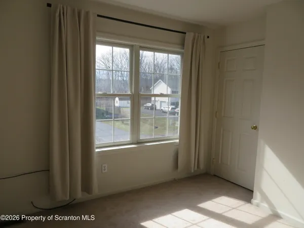 a view of a livingroom with an empty space and a window