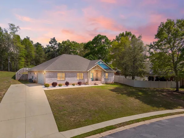 a front view of a house with a yard and trees