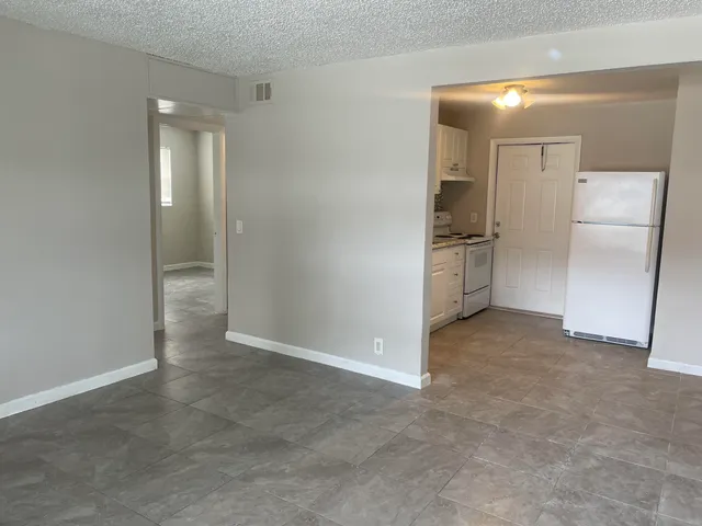 a view of a kitchen with a refrigerator and a sink