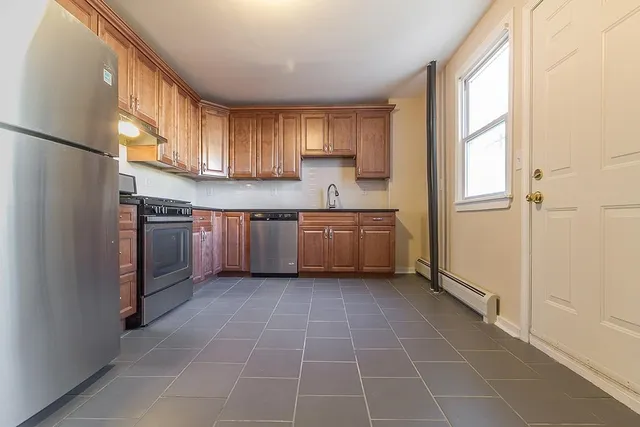 a kitchen with stainless steel appliances a refrigerator sink and cabinets