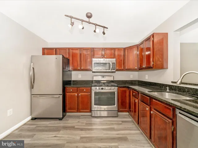 a kitchen with granite countertop a stove and cabinets