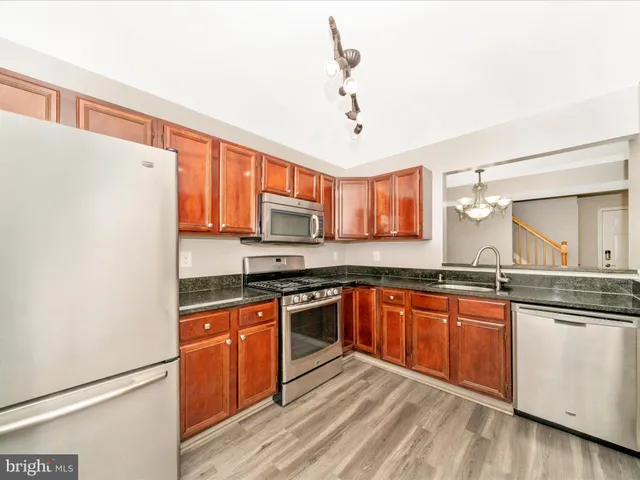 a kitchen with granite countertop a refrigerator stove and microwave