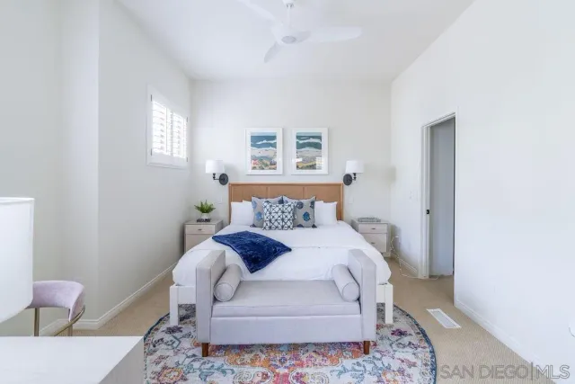 a bedroom with a bed and a painting on the wall