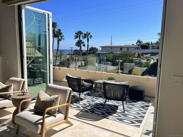 a view of a patio with a table chairs and a floor to ceiling window