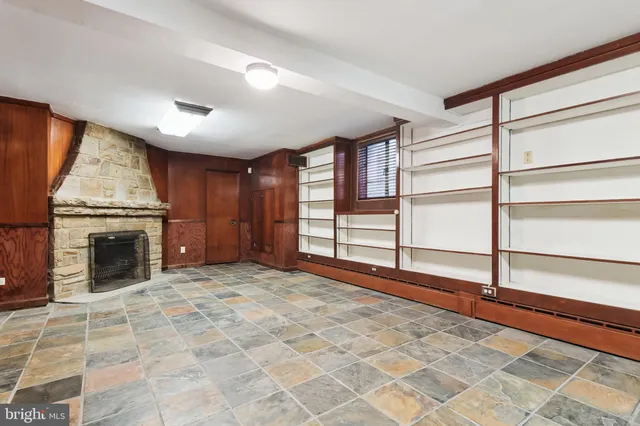 a view of an empty room with a fireplace and a window