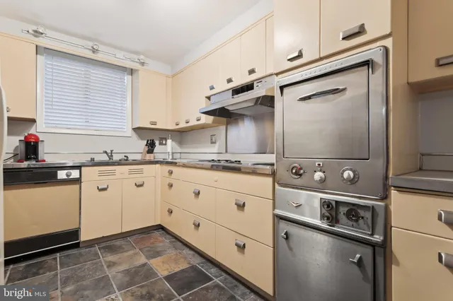 a kitchen with stainless steel appliances cabinets and a window