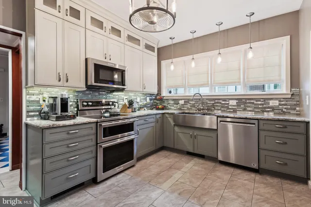 a kitchen with stainless steel appliances granite countertop a stove sink and cabinets