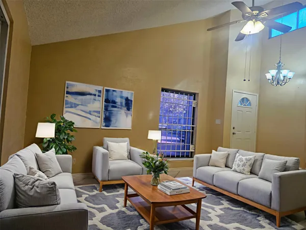 a living room with furniture a chandelier and a window
