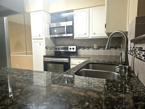 a kitchen with stainless steel appliances a refrigerator sink and cabinets