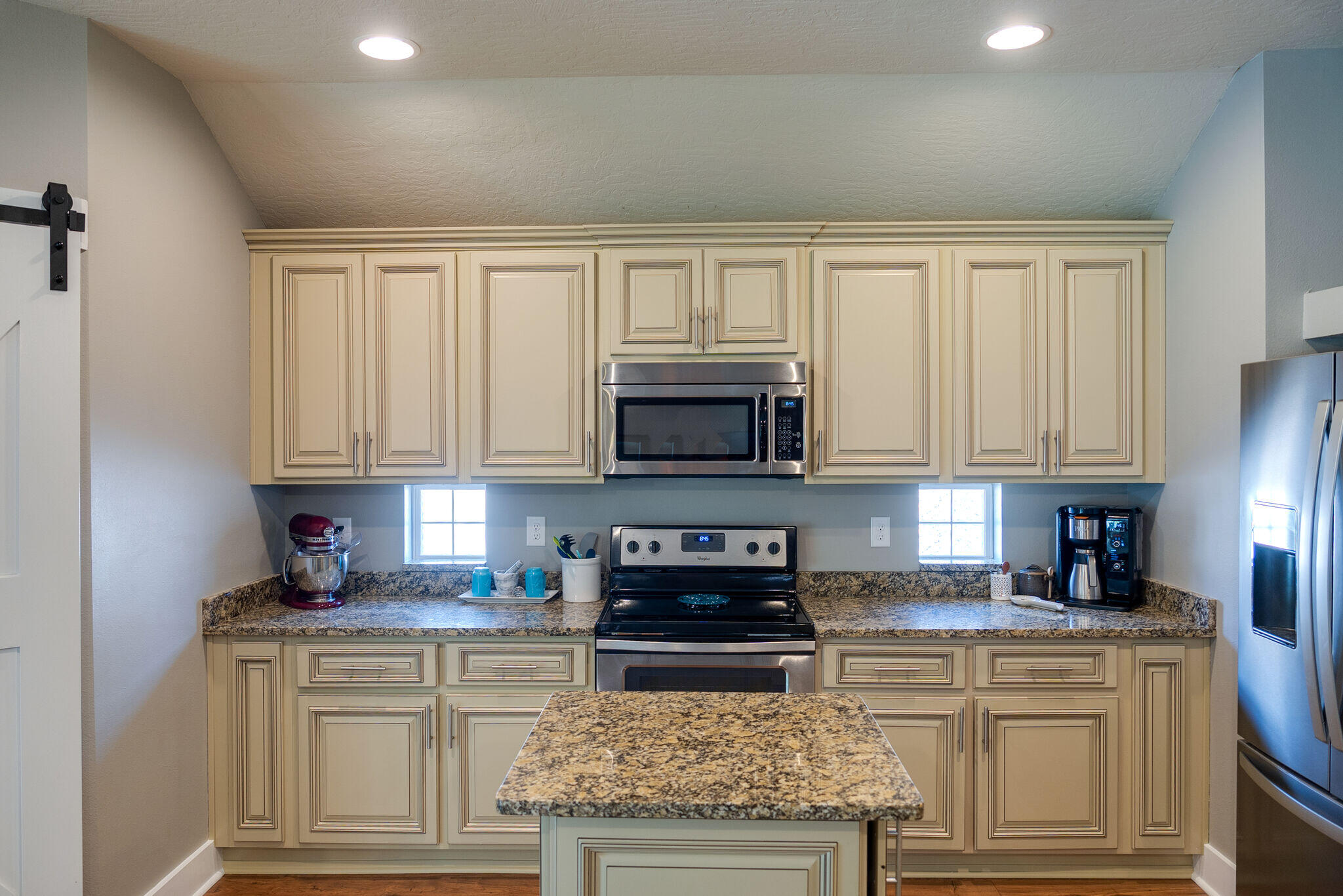 4723 Chanson Crossing Crestview, FL 32539 - Photo 18 of 58 a kitchen with stainless steel appliances granite countertop a stove a sink dishwasher and a refrigerator with white cabinets