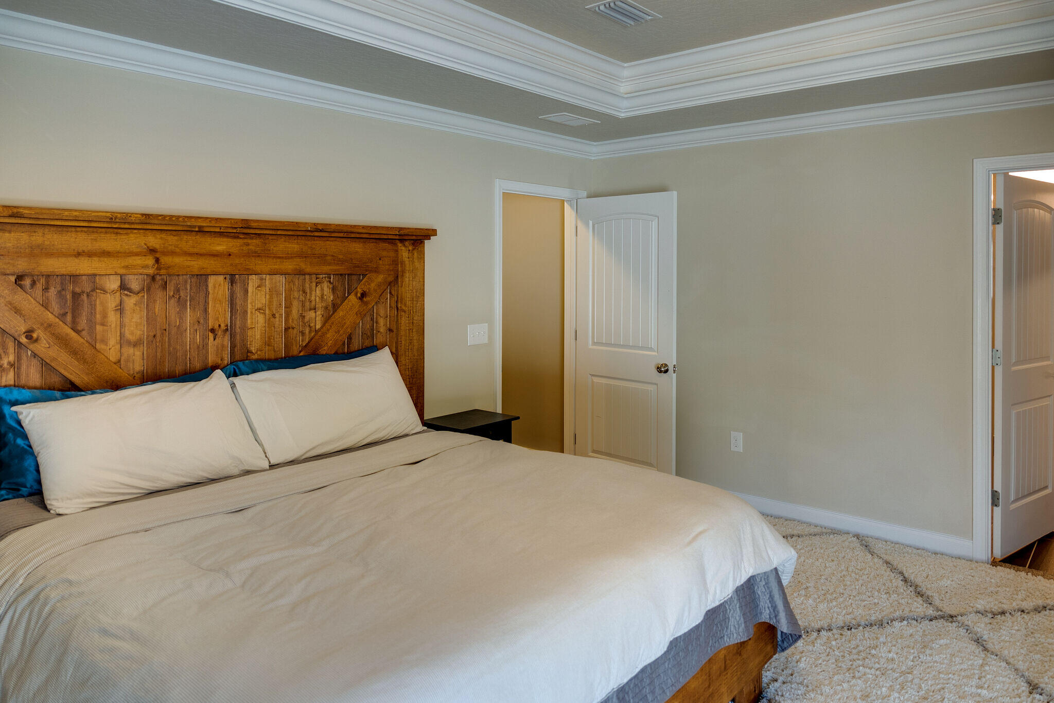 4723 Chanson Crossing Crestview, FL 32539 - Photo 26 of 58 a bedroom with a large bed and wooden floor
