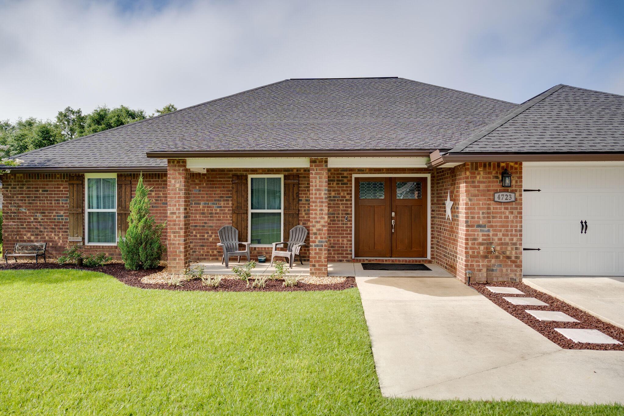 4723 Chanson Crossing Crestview, FL 32539 - Photo 3 of 58 a front view of a house with a garden and patio