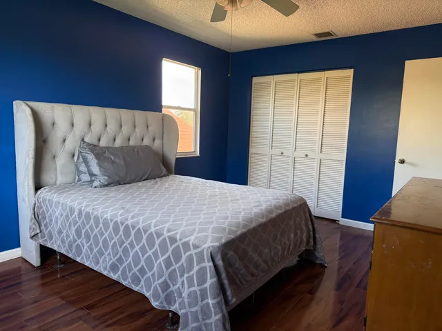 a bedroom with a bed and wooden floor